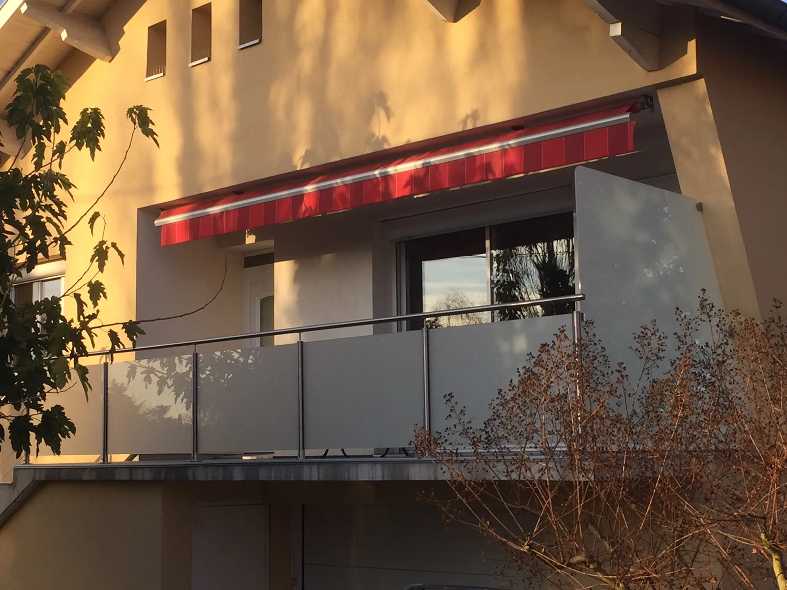 Brise-vue en verre opale séparant deux espaces de terrasse