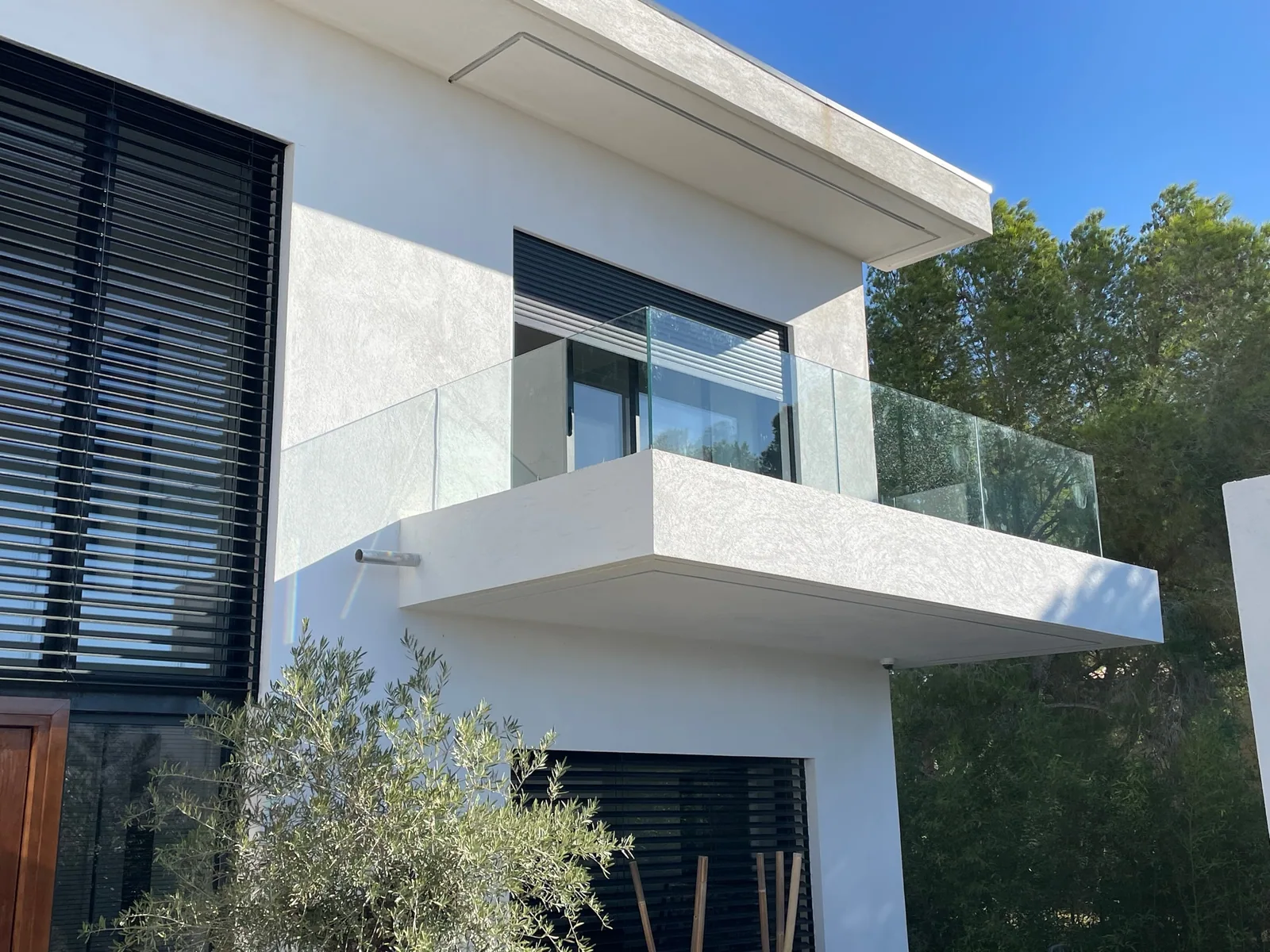 Garde-corps tout verre installé sur un rail aluminium autour d’un balcon contemporain
