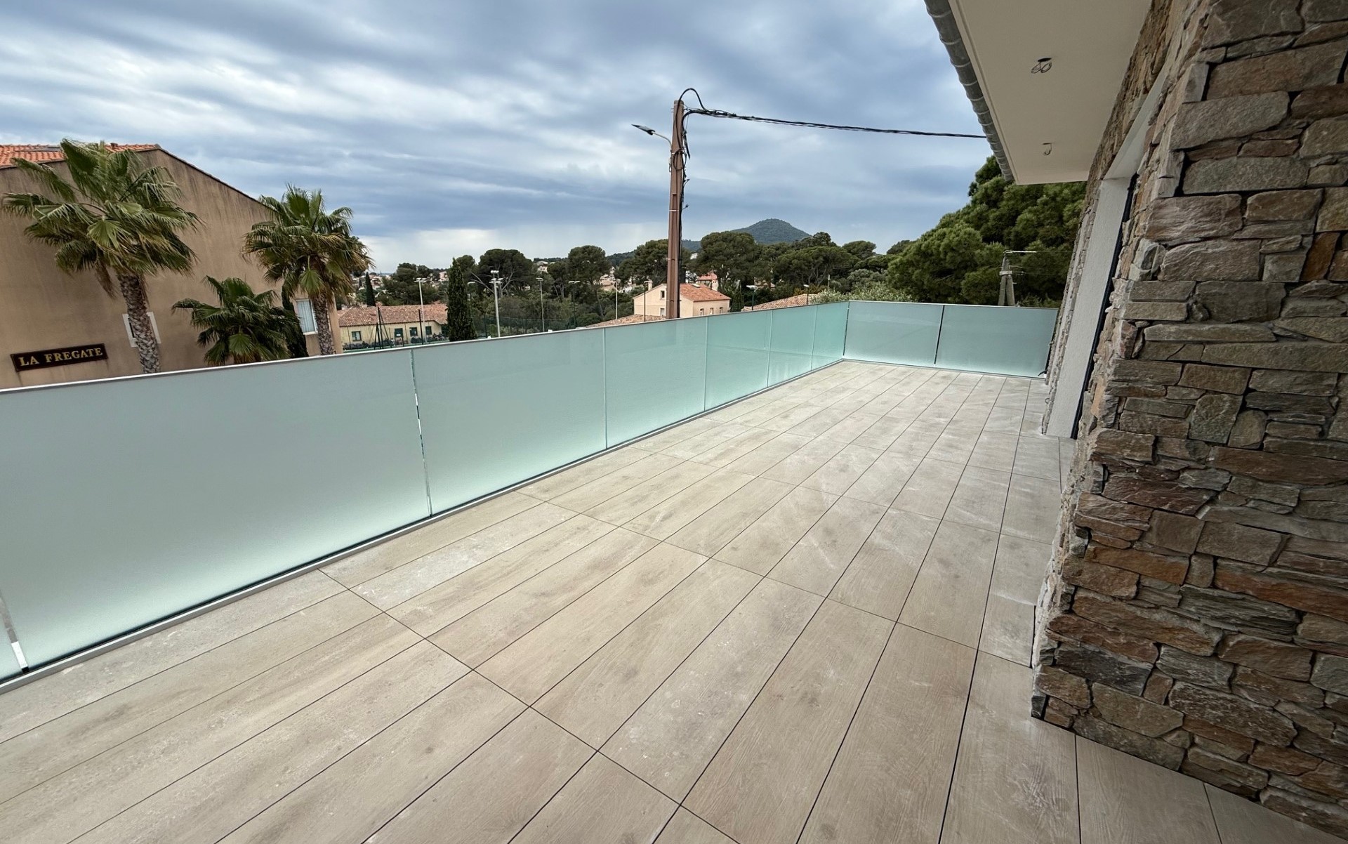 Rambarde en verre dépoli pour terrasse carrelée sur rail aluminium, avec vitrage 16,76 mm. Rambarde en verre dépoli 16,76 mm posée sur terrasse carrelée avec profilé aluminium continu, pour une protection moderne en extérieur.