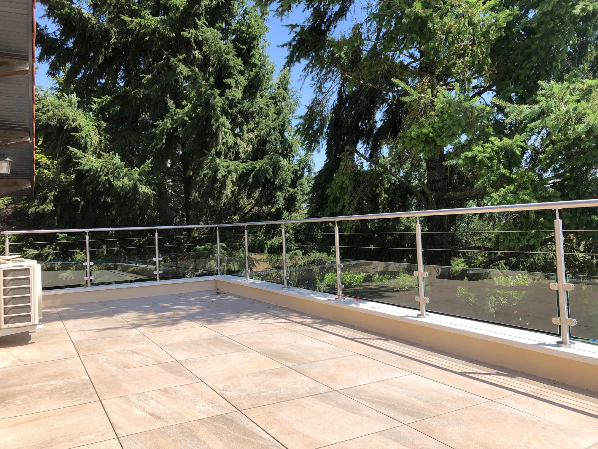 Balustrade extérieure en verre et inox suivant le contour d’un balcon