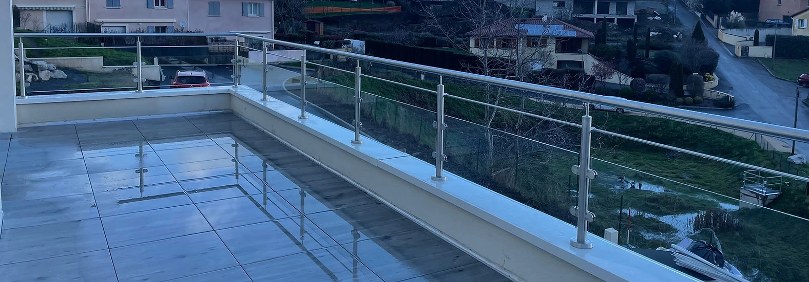 Rambarde en verre installée sur un acrotère de toit-terrasse à Lyon