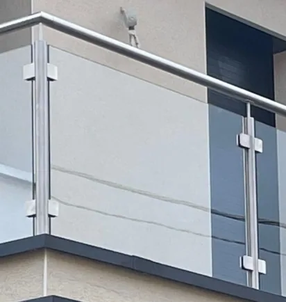 Pince inox maintenant un panneau de verre sur un poteau de garde-corps