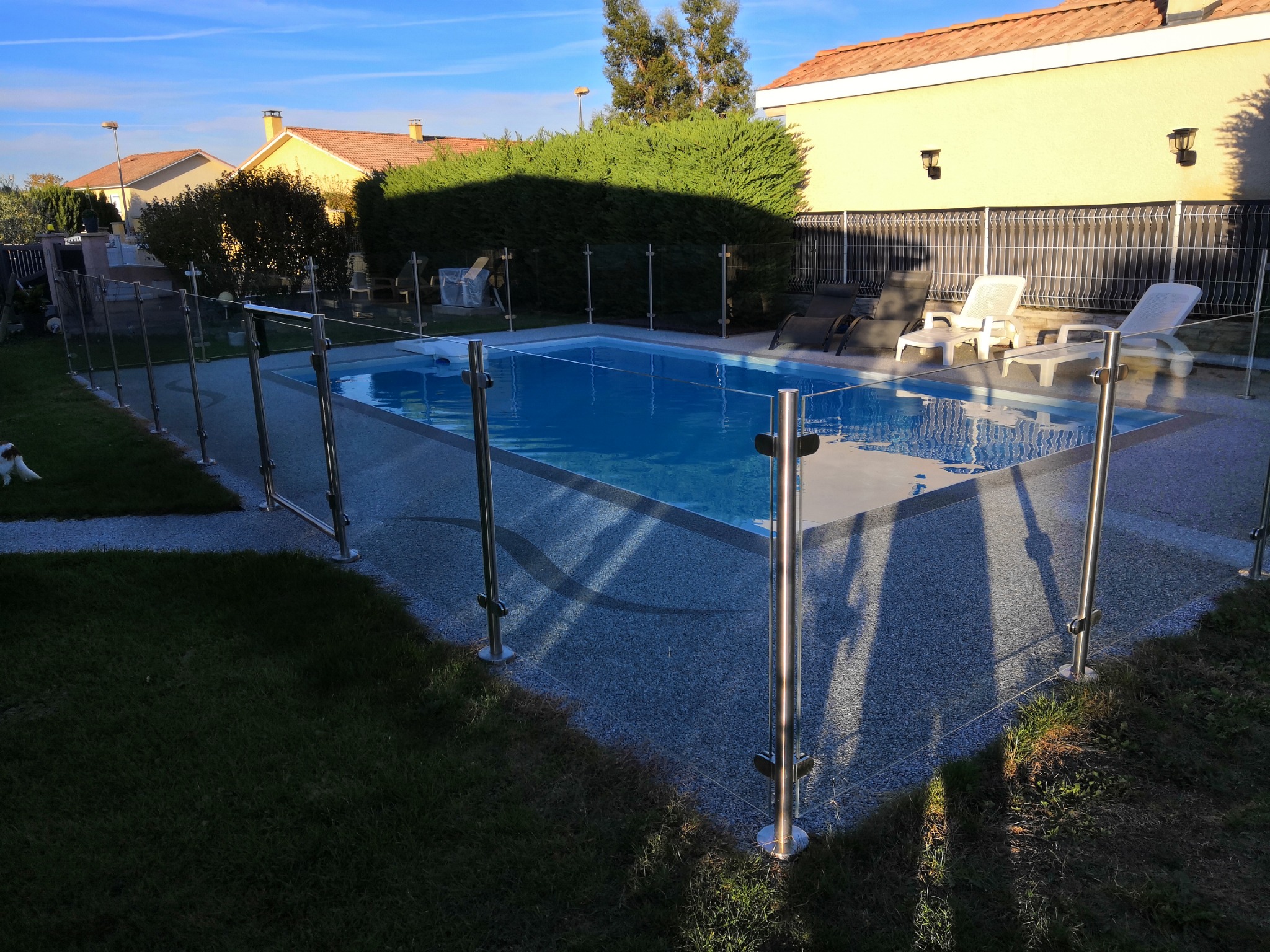 Aperçu d’une barrière de piscine en verre 8,76 mm répondant à la norme NF P90-306. Installation d’une barrière de piscine en verre 8,76 mm répondant à la norme NF P90-306, en extérieur