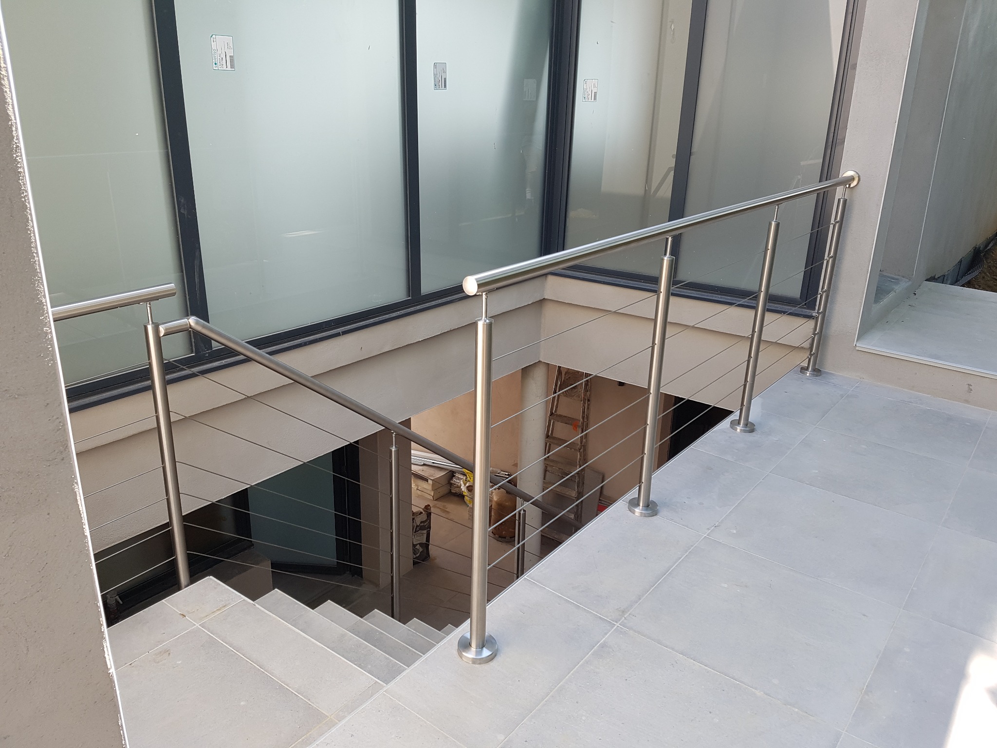Pose d’un garde-corps en inox 304 à câbles pour mezzanine sur carrelage, sur poteaux inox et avec tendeurs de câbles