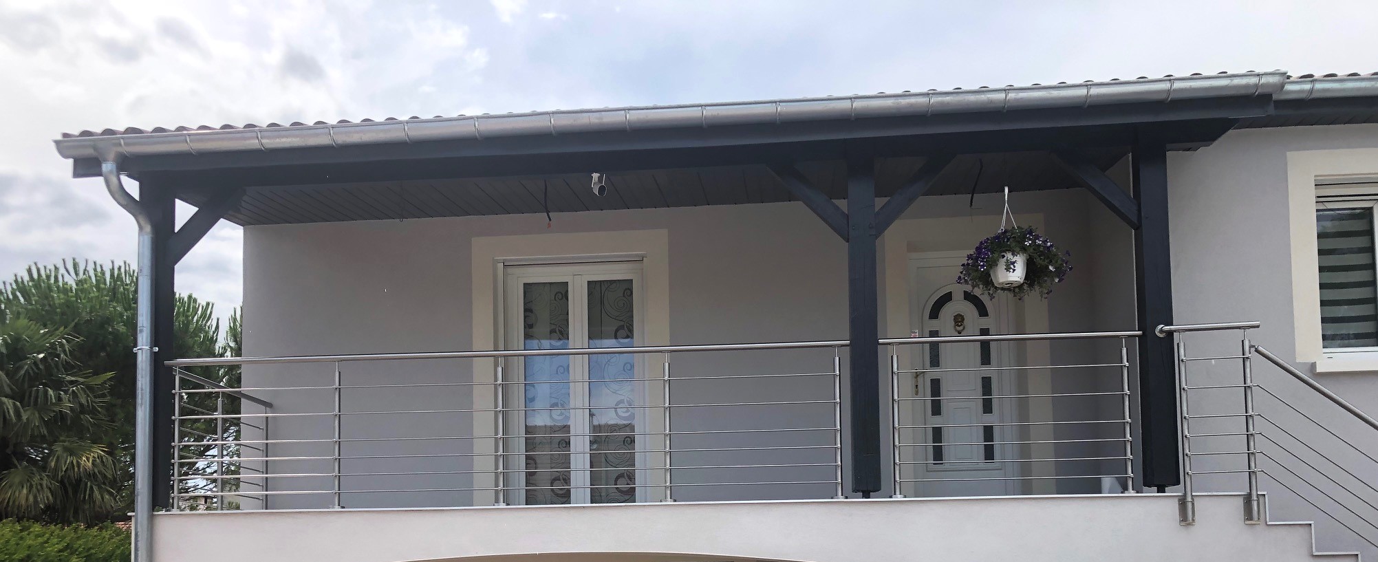 Vue d’un garde-corps en inox à lisses pour balcon, monté sur poteaux inox. Garde-corps extérieur en inox brossé à lisses horizontales pour balcon, sur poteaux inox et en pose à la française