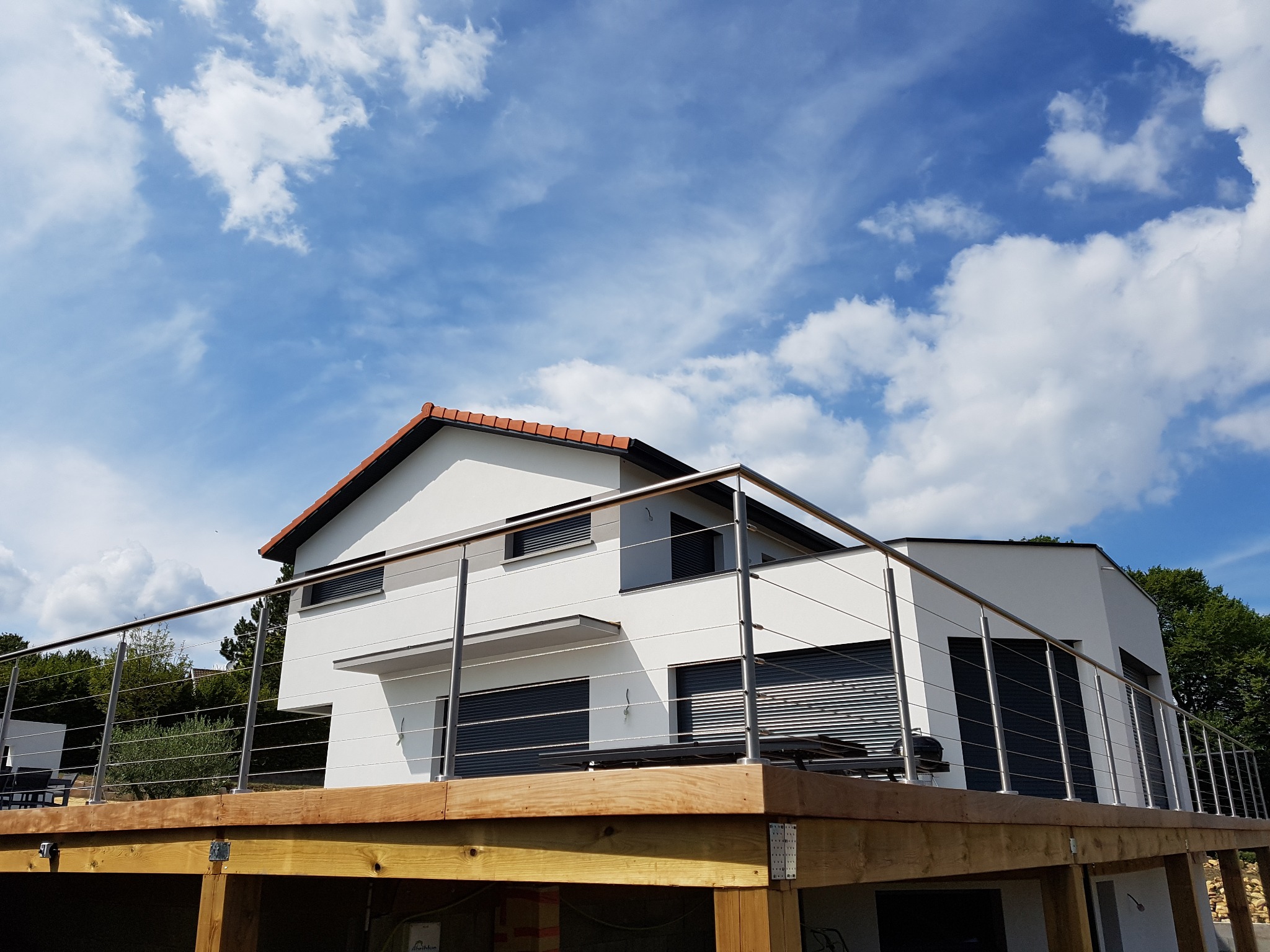 Détail d’un garde-corps en inox à câbles pour terrasse bois, avec câbles tendus. Garde-corps en inox 316 à câbles tendus pour terrasse bois, sur embase de fixation horizontale