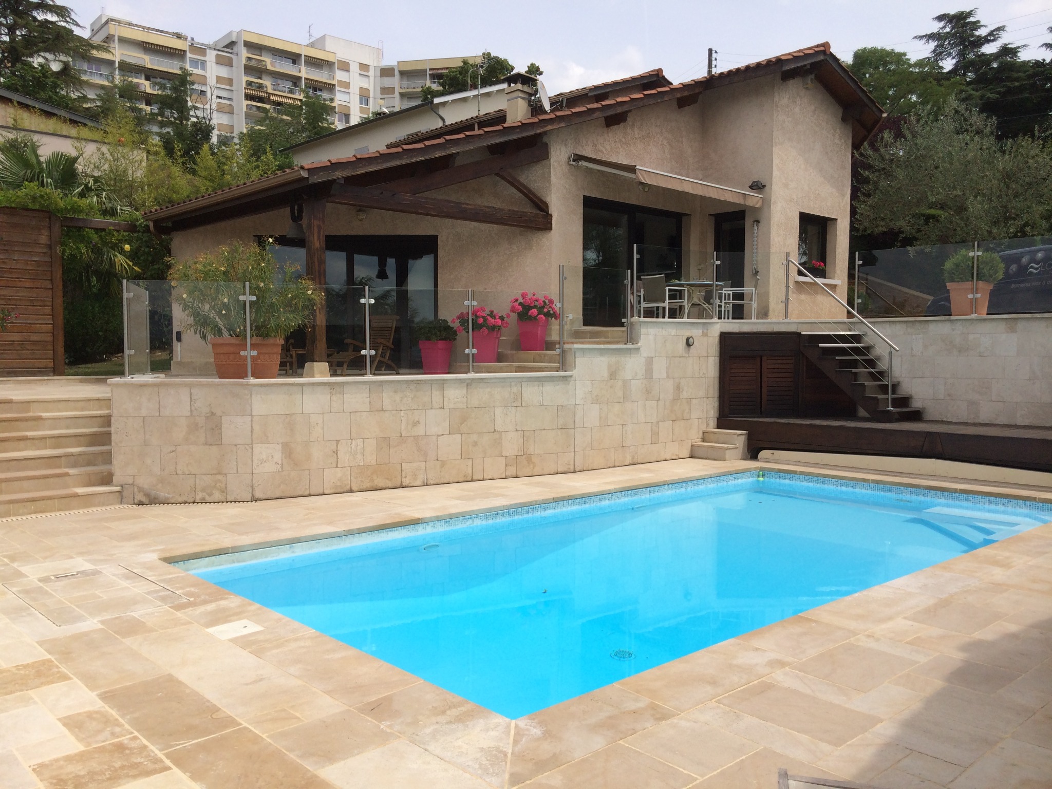 Détail d’une rambarde tout verre pour piscine sans montants, avec panneaux vitrés. Rambarde tout verre feuilleté fabriquée aux abords de piscine, résistante au chlore et avec panneaux vitrés