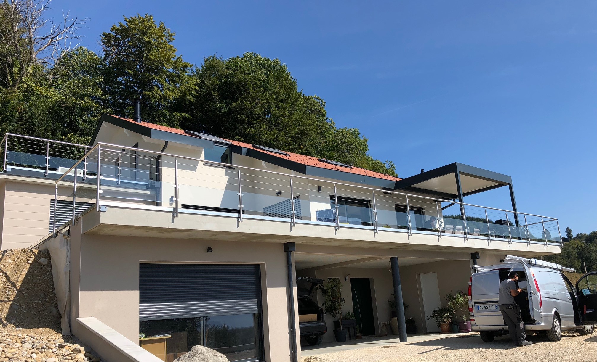 Détail d’une rambarde en verre 44/2 et câbles inox pour terrasse avec fixation latérale. Pose en applique d’une rambarde en verre 44/2 et câbles inox pour terrasse, sur poteaux inox et avec tendeurs de câbles